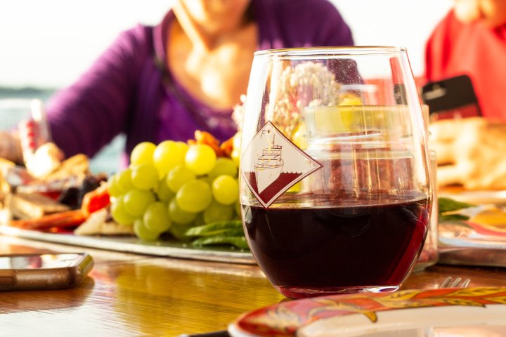 a woman sitting at a table with a glass of wine