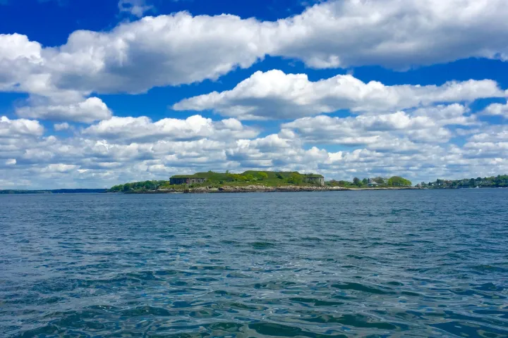 a large body of water with a cloudy blue sky