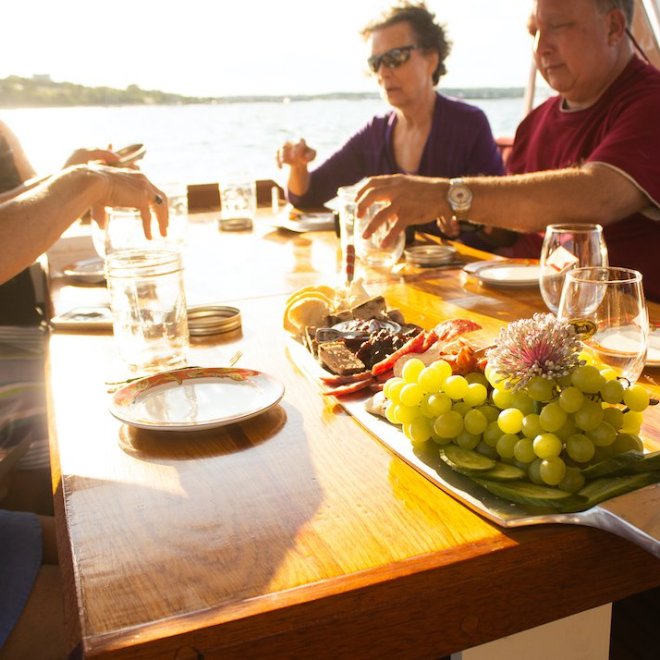a group of people sitting at a table with food and water