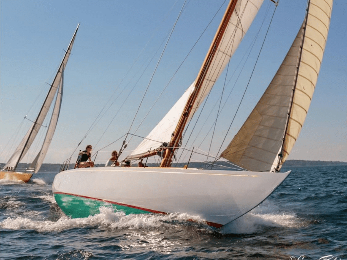 Historic GLEAM sailing yacht heeling in the wind while sailing on the ocean.